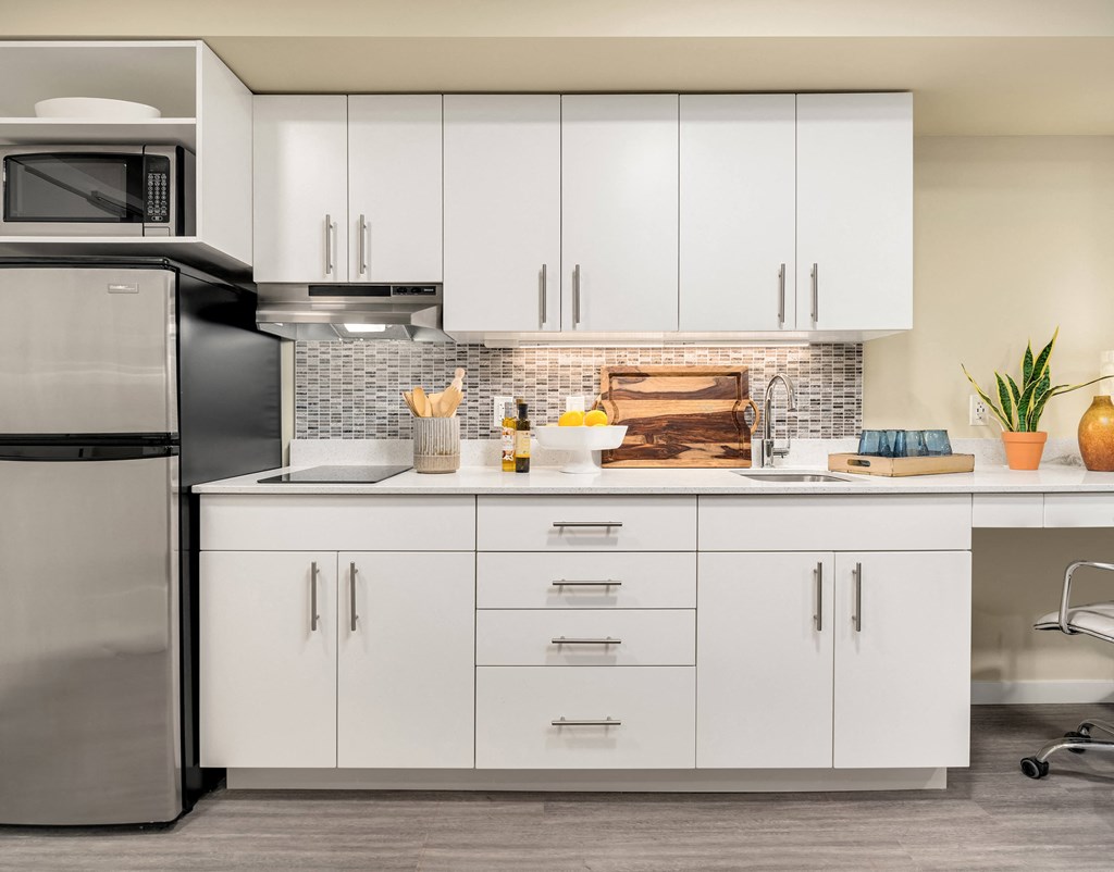 a kitchen with white cabinets and stainless steel appliances