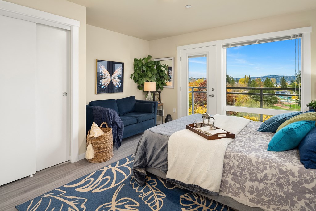 a bedroom with a bed and a couch and a window