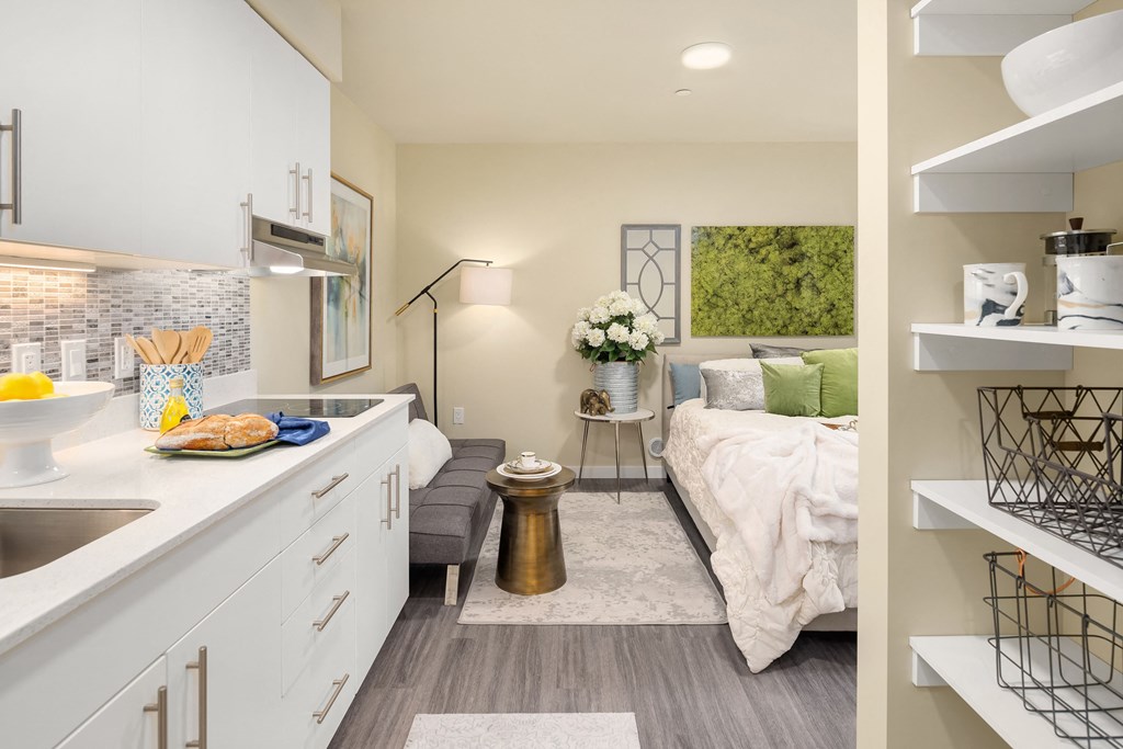 a renovated kitchen with a bedroom in the background