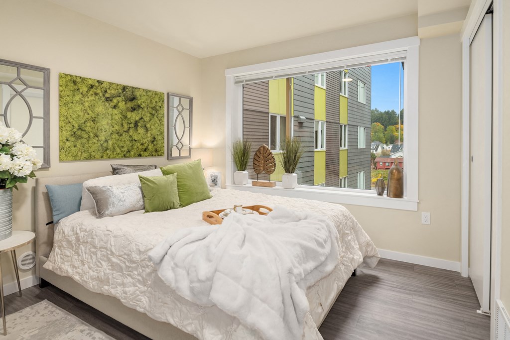 a bedroom with a large window and a bed