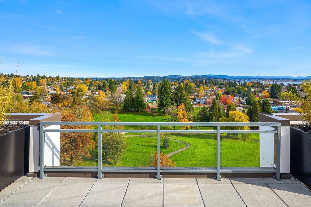 the view from the balcony of a building overlooking a green field and trees
