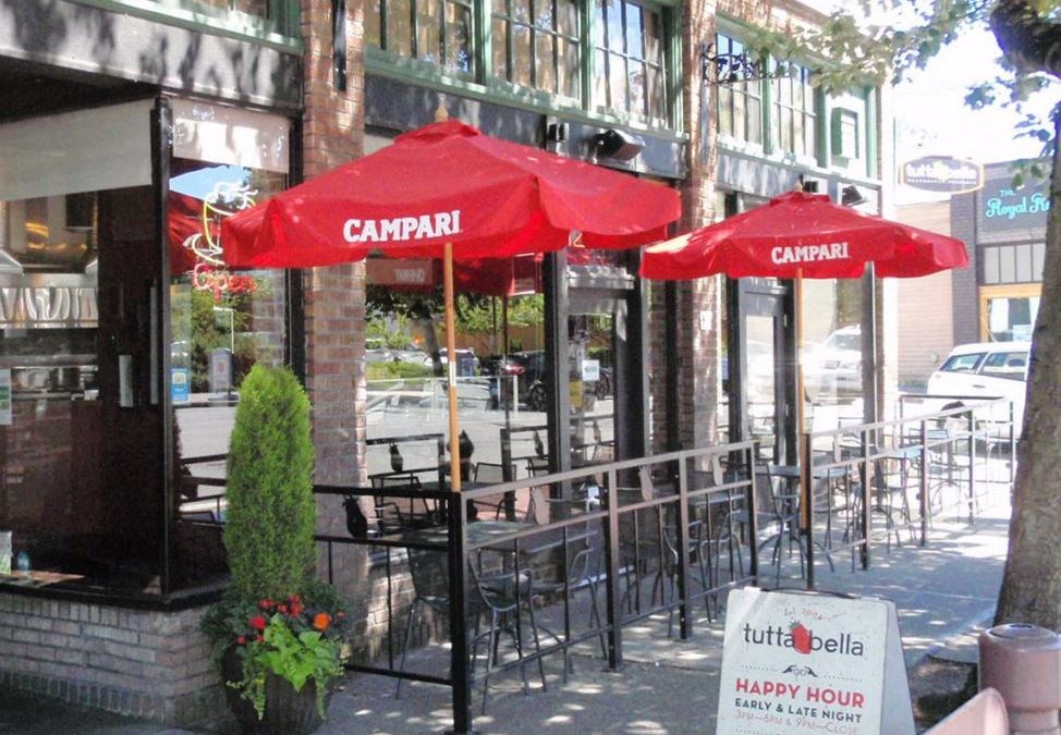 the outside of a restaurant with red umbrellas
