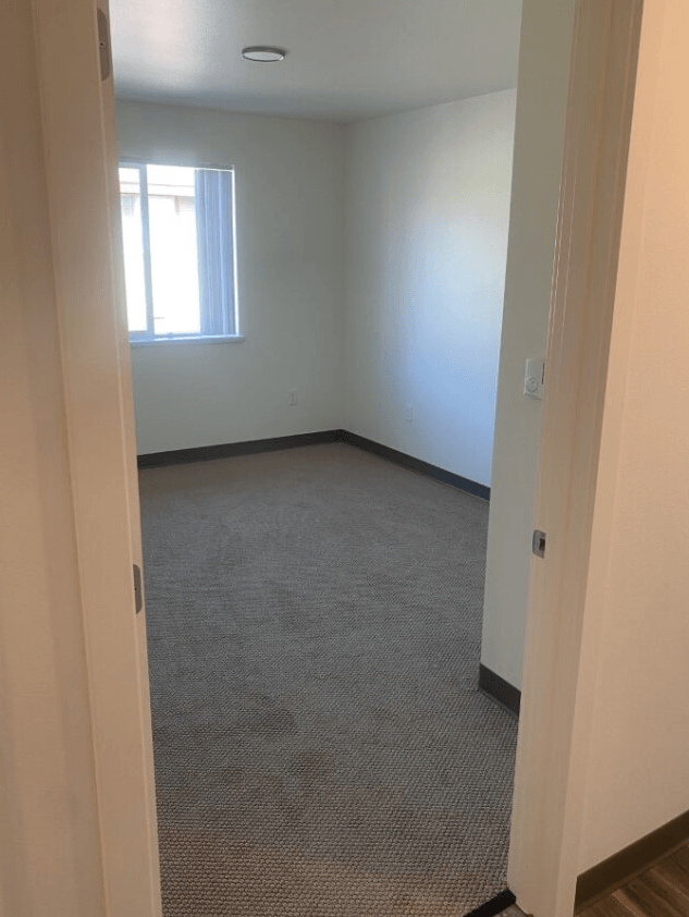 a room with a carpeted floor and a window