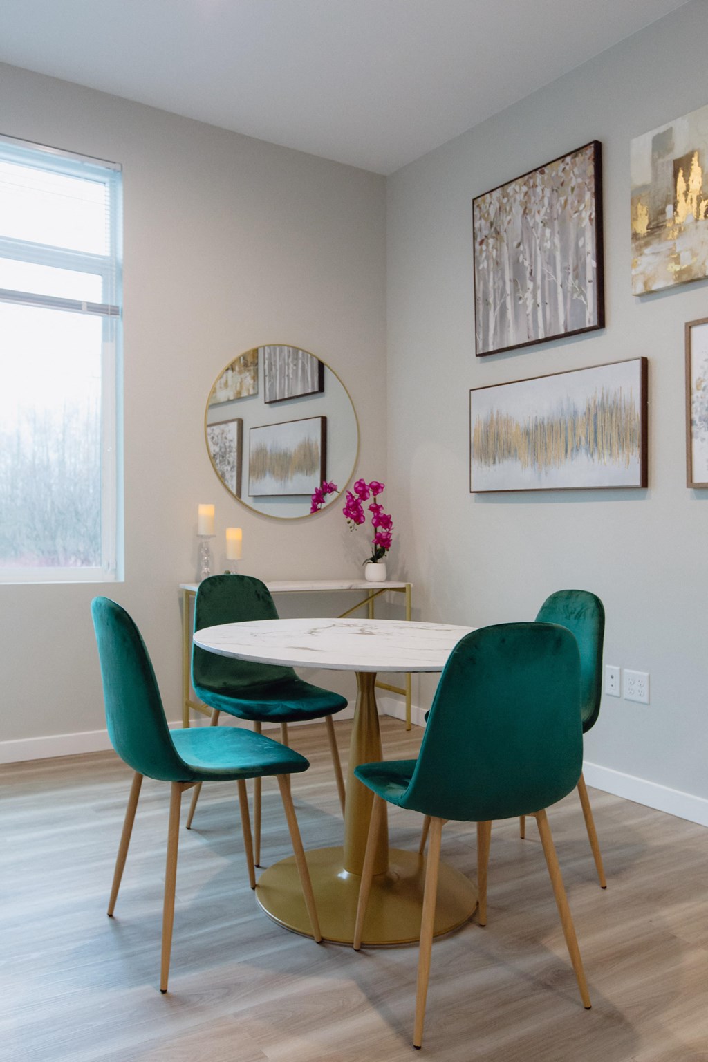 a dining room with a white table and green chairs