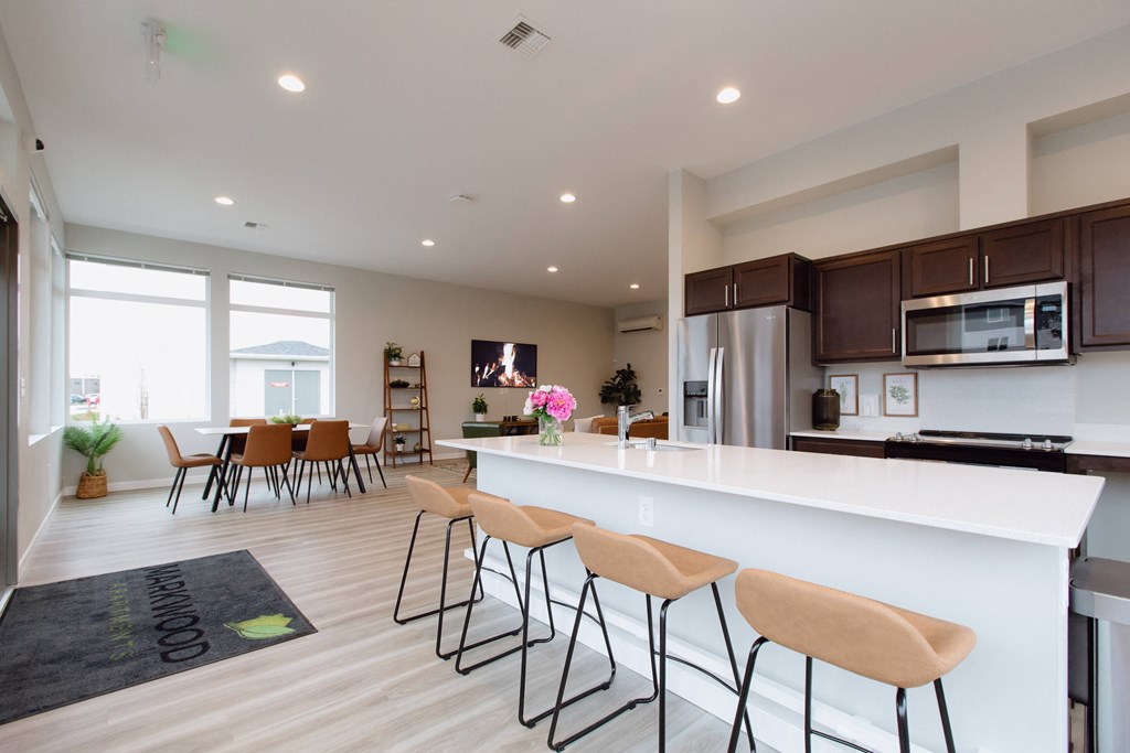 an open kitchen and dining room with a large white counter top and chairs