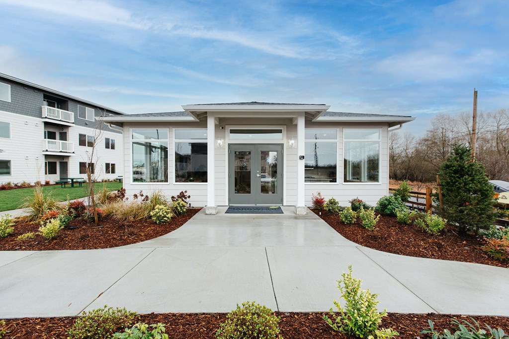 the view of the entrance to a building with glass windows and a concrete walkway