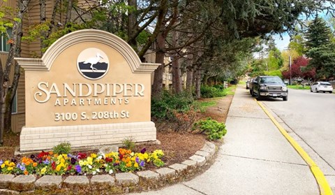 a sign on the side of a sidewalk in front of a building