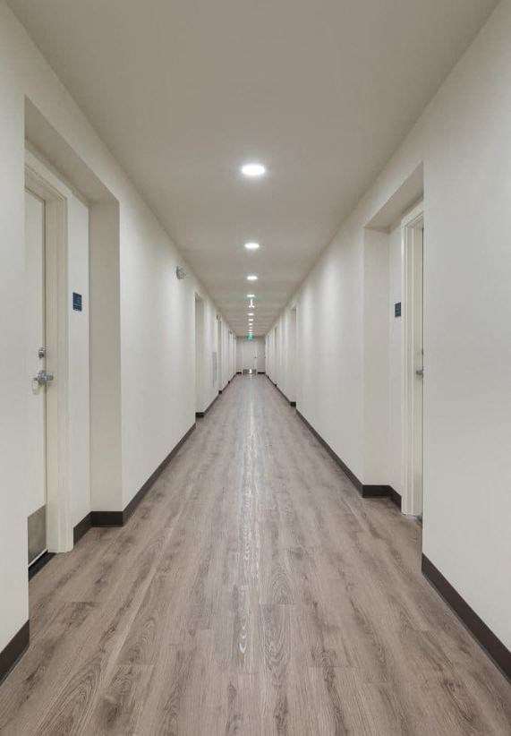 a long hallway with white walls and doors