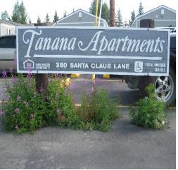 a sign for tomani apartments in front of a parking lot