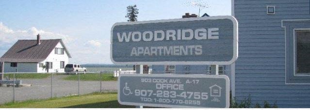 a sign for woodridge apartments in front of a house