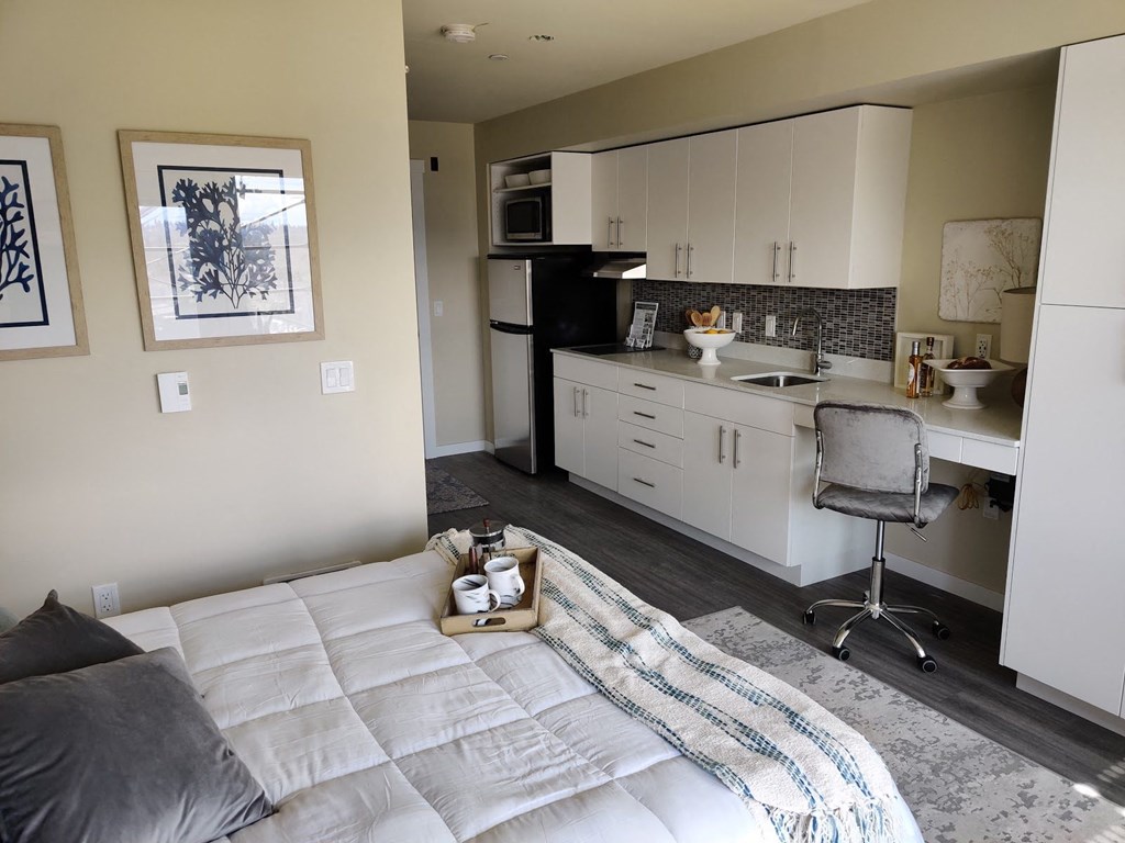 a studio apartment with a bed and a kitchen