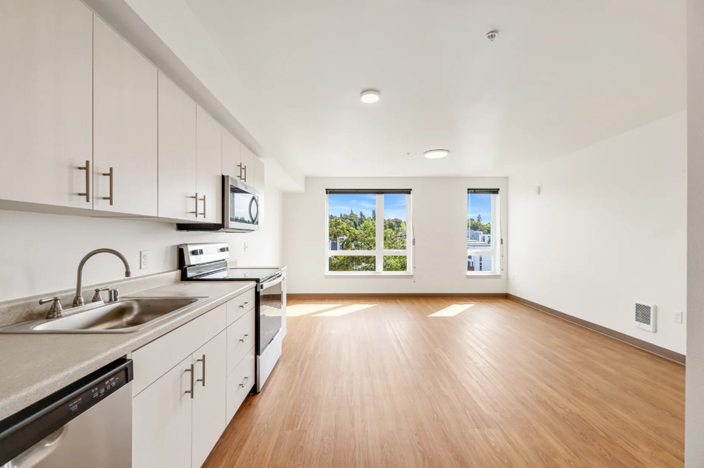a kitchen with white cabinets and a sink and a window