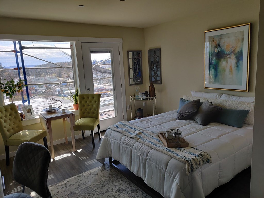 a bedroom with a bed and a desk and a window