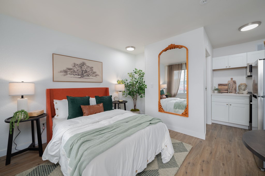A bedroom with a large bed and a mirror on the wall.