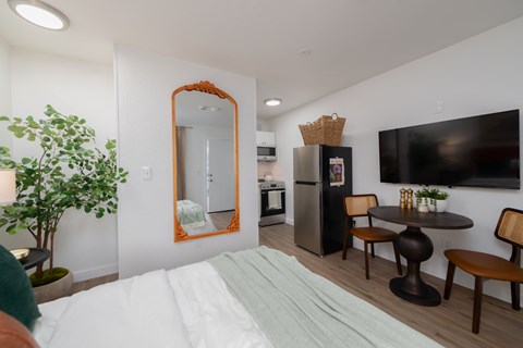 A bedroom with a large bed and a mirror on the wall.
