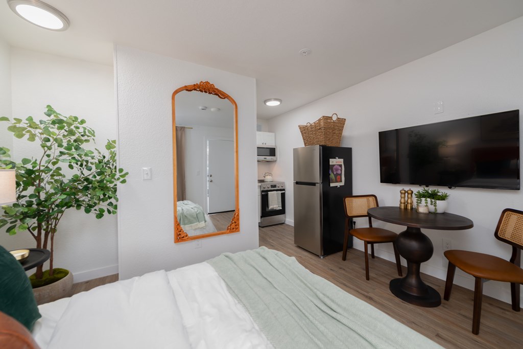 A bedroom with a large bed and a mirror on the wall.