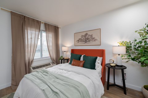 A bedroom with a large bed and a red headboard.