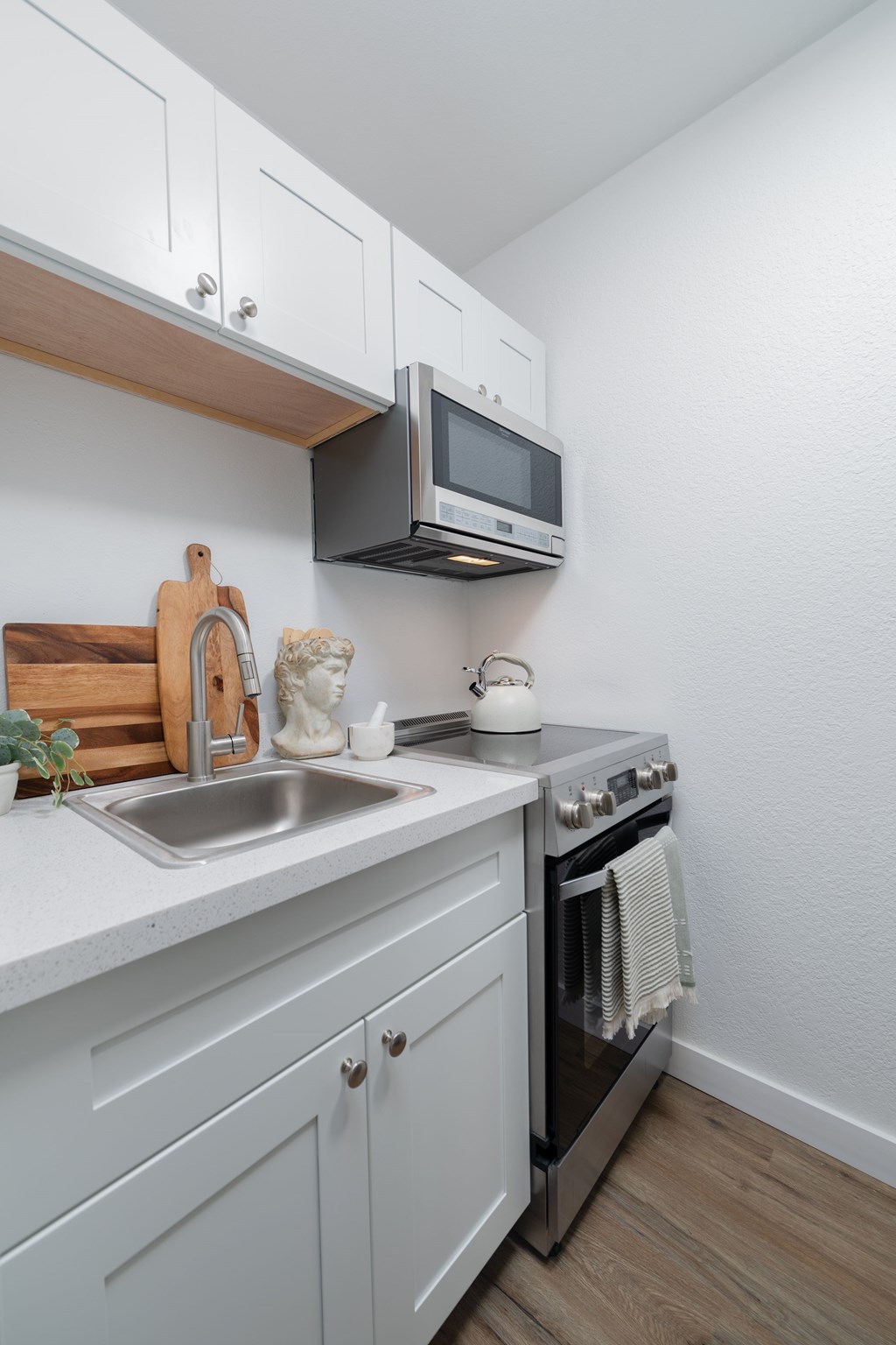A kitchen with a white countertop and a stainless steel dishwasher.