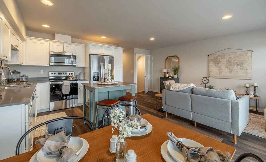 A modern kitchen with a dining table set for two.