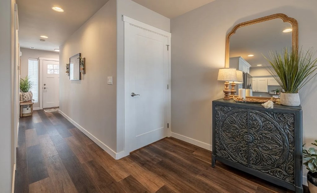 A black and white hallway with a wooden floor and a black cabinet.