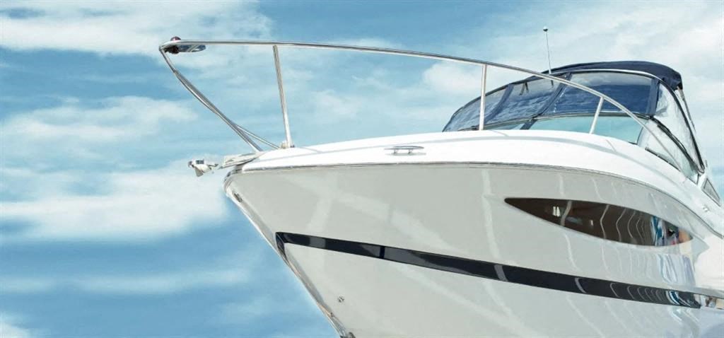 a white boat against a blue sky with clouds