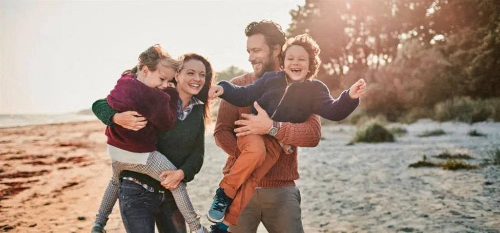 a family posing for a picture on the beach