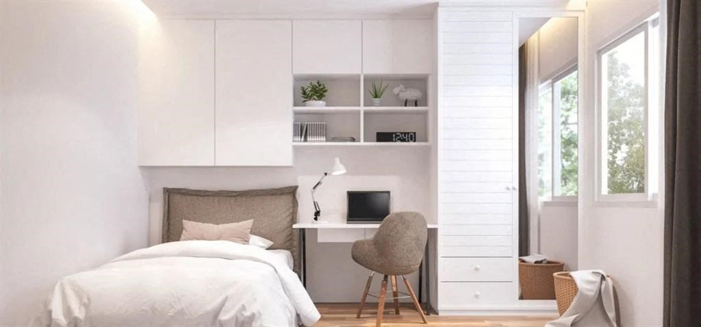 a bedroom with a bed and a desk with a computer