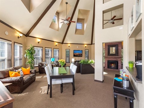 a large living room with a table and a fireplace