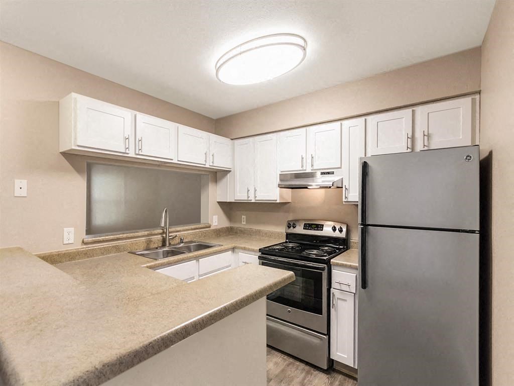 a kitchen with stainless steel appliances and white cabinets