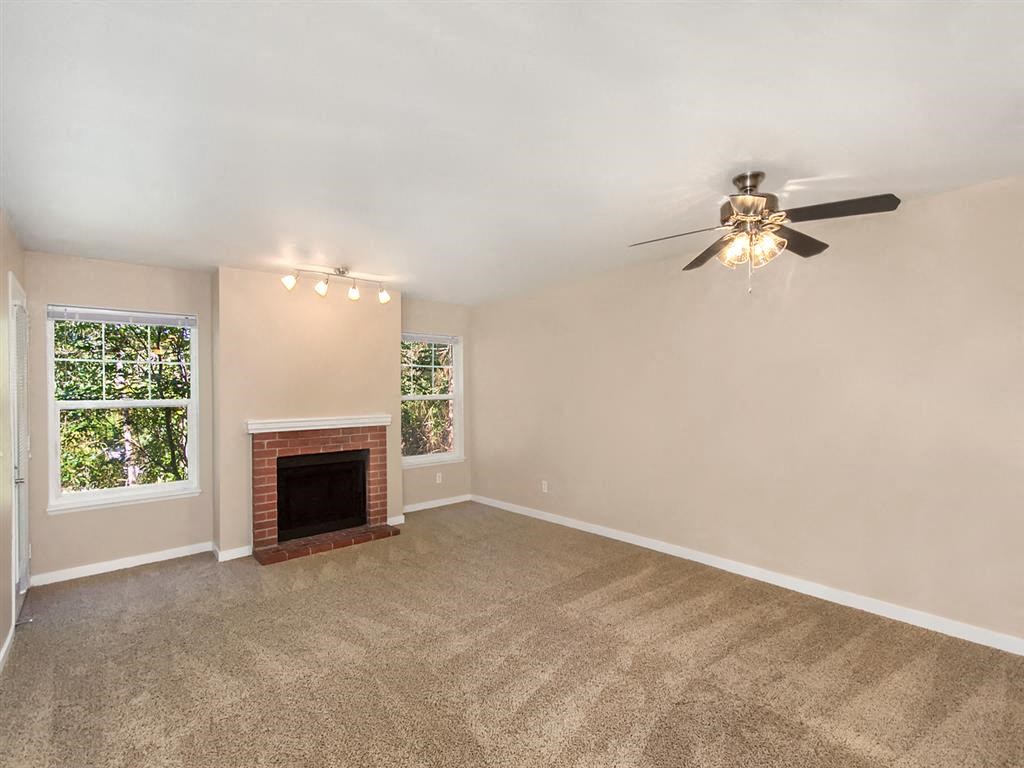 a living room with a fireplace and a ceiling fan