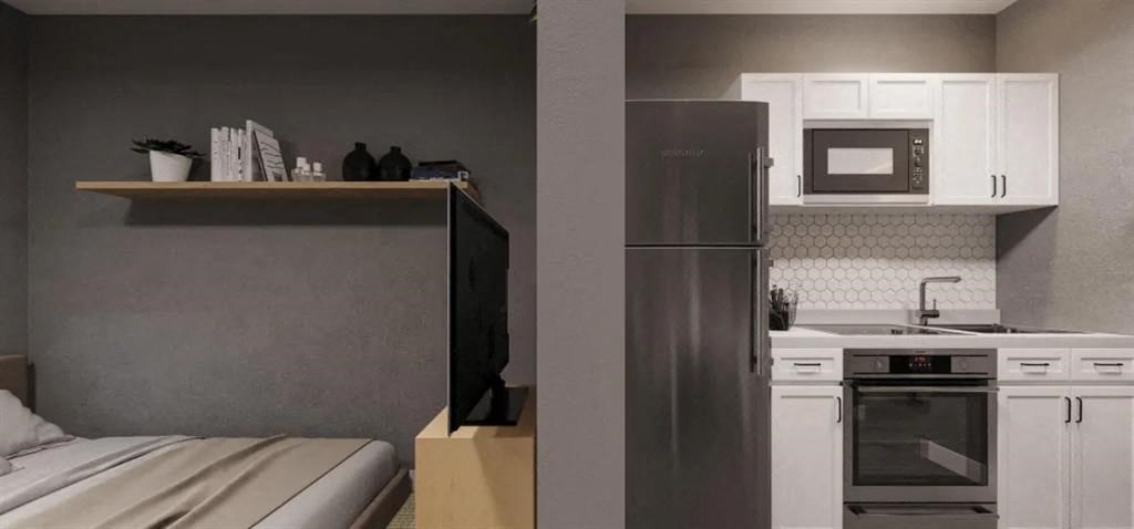 a kitchen with a refrigerator and a bed