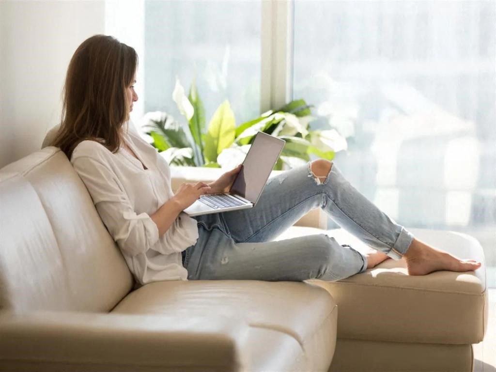 a woman sitting on a couch with a laptop