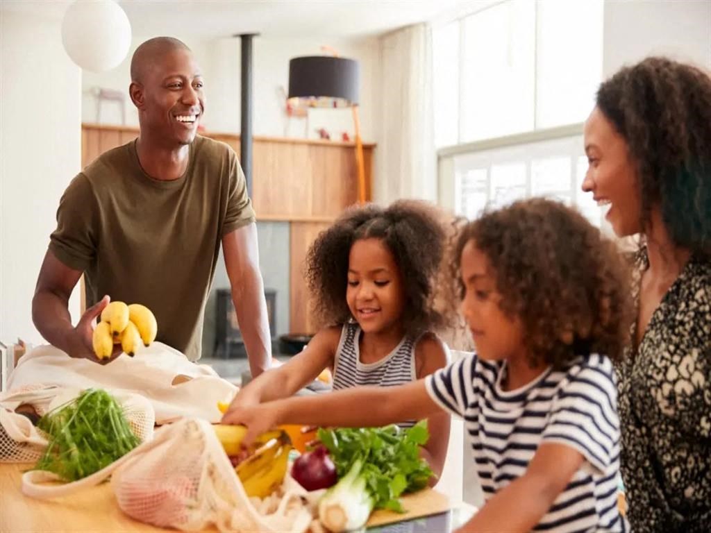 a family prepares a meal together in the kitchen