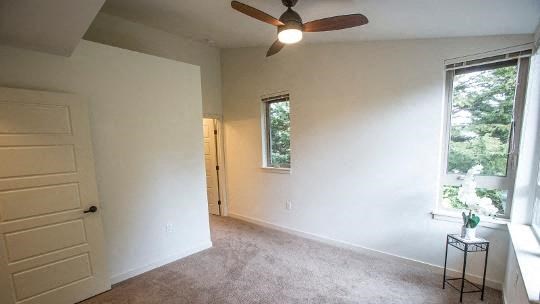 a living room with a ceiling fan and a window