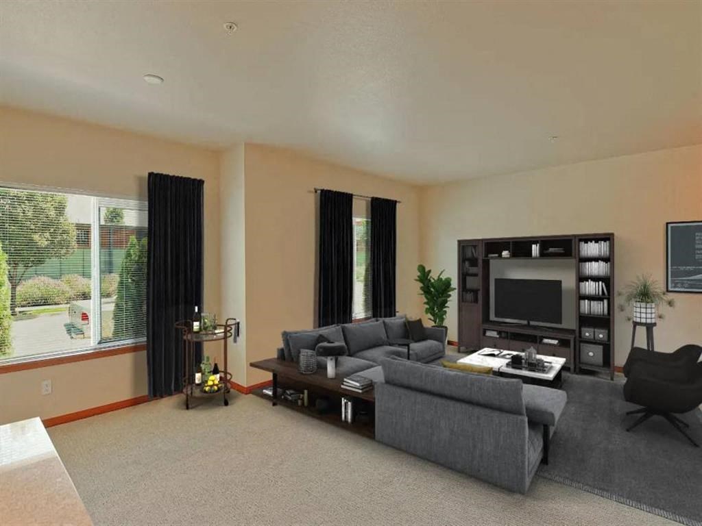 a large living room with a gray couch and a tv
