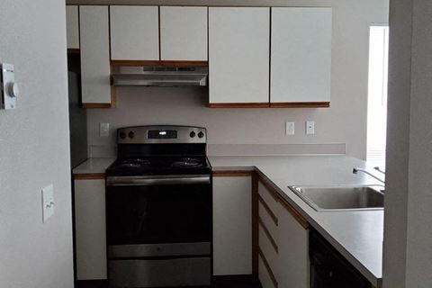 an empty kitchen with a stove and a sink