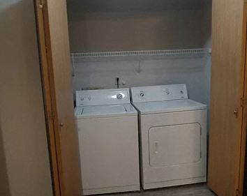 a white washer and dryer in a small laundry room