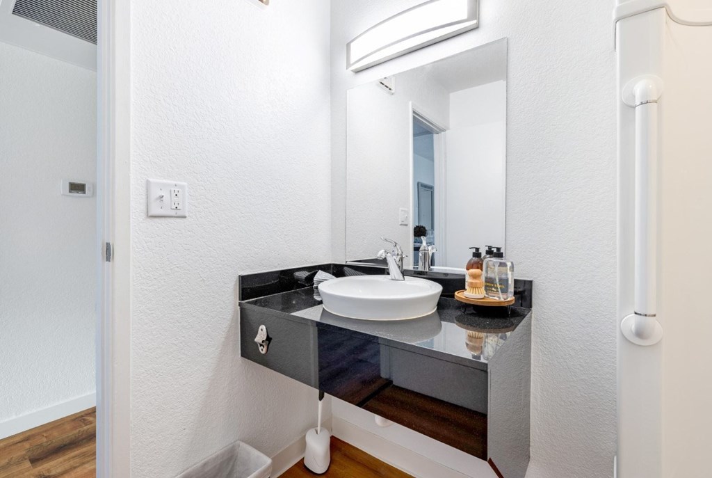 A bathroom with a sink and mirror.