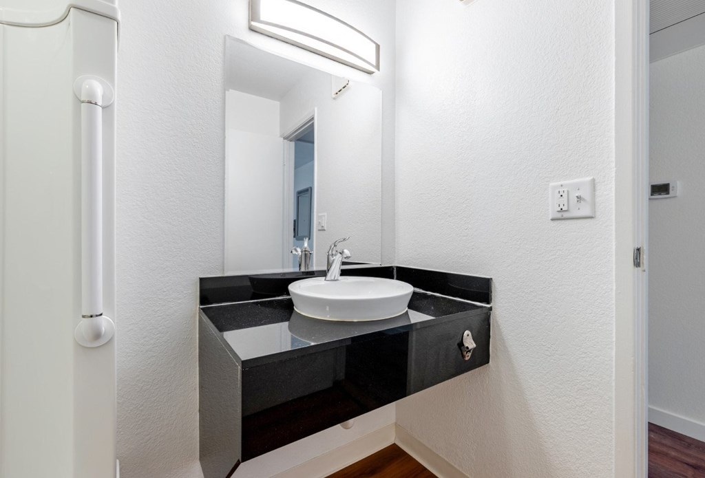 A bathroom with a sink and mirror.