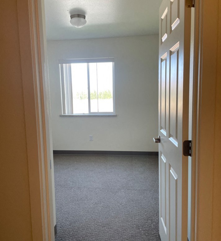 an empty room with a window and a door