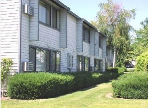 A white building with a green lawn in front.