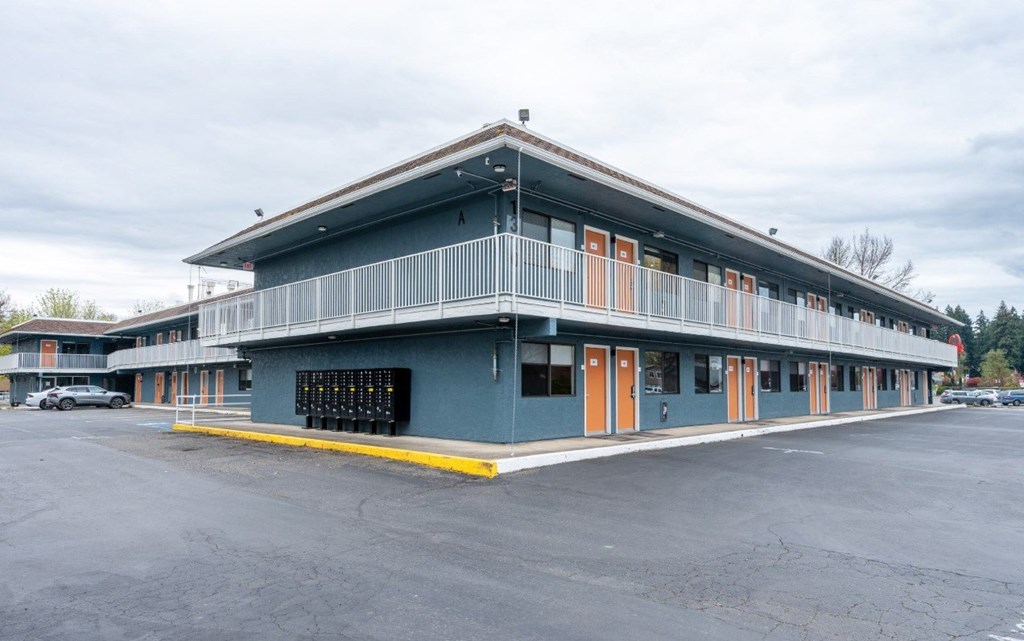A large building with a blue exterior and orange doors.