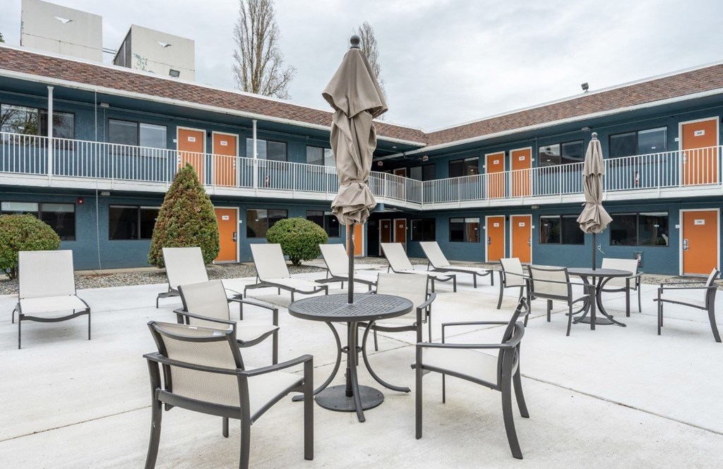 A patio with chairs and tables is set up outside a building.