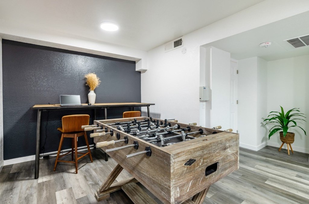 A modern kitchen with a wooden island and a black wall.