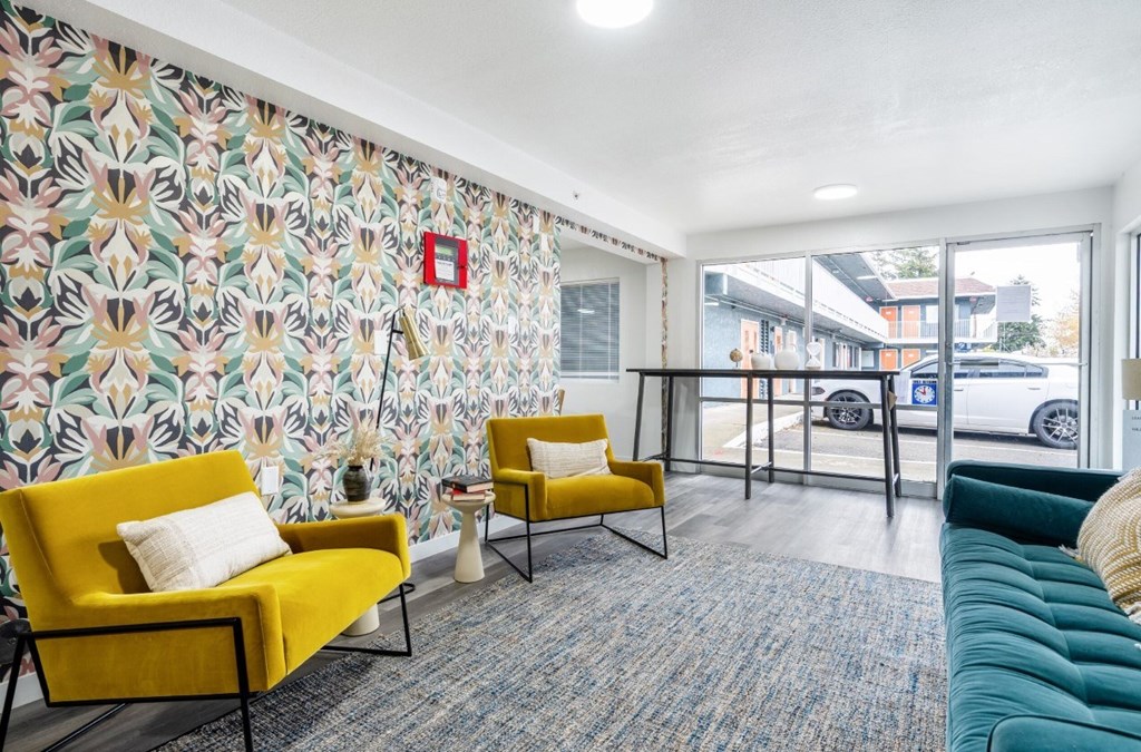 A brightly colored waiting room with yellow chairs and a patterned wallpaper.
