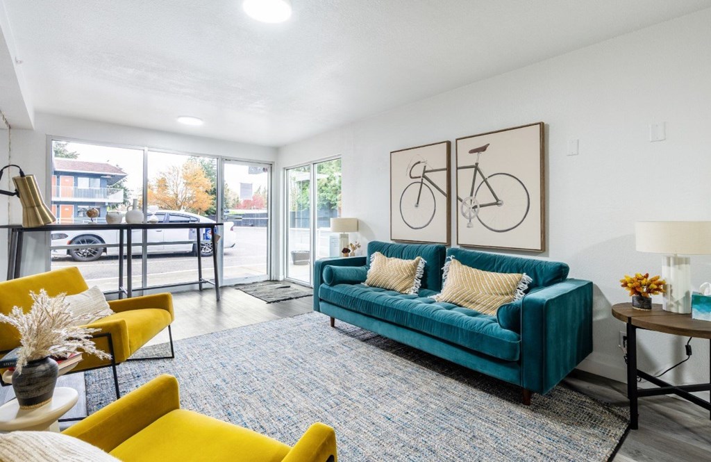 A living room with a blue couch and yellow chairs.