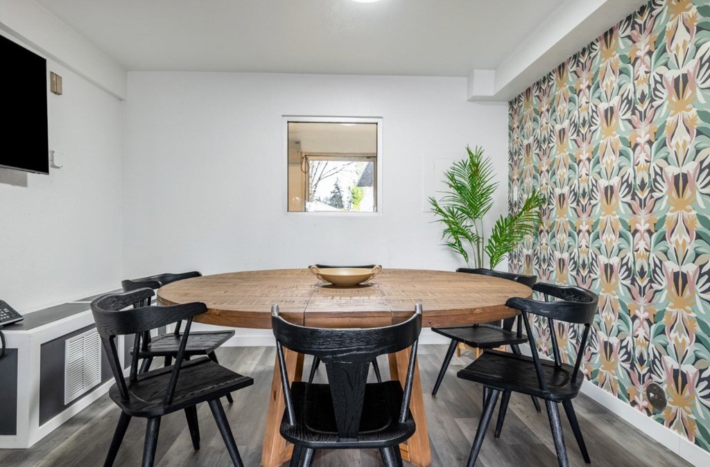 A dining room with a wooden table and chairs.