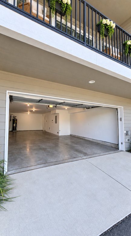 A garage door is open to reveal a clean, empty garage.
