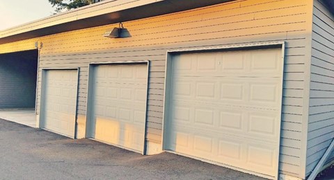 Three garage doors are closed and one is open.