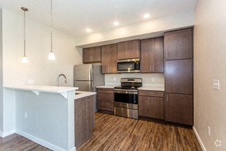 a kitchen with wooden floors and stainless steel appliances